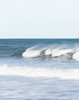 Ocean waves crashing on a beach with a clear sky