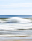 Abstract image of a beach scene with ocean waves and blurred blue green and white lines