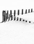 Black and white photo of a beach fence fence on a white sandy background at Nauset Beach