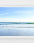 A framed artwork depicting an abstract and serene beach scene with the blue ocean and sky