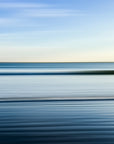 An abstract photograph featuring a blurred ocean background with a warm sunset glow.