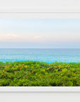 This image presents an artwork titled "Nassau Outlook," featuring a vibrant print of a Bahamian landscape. The artwork captures the serene view of the turquoise ocean meets the lush, greenery.