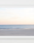 An abstract photograph of a soft and serene beach scene with a calm ocean, clear sky and blue, beige and pink tones