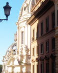 photograph of a building facade with a classic street lamp in the foreground, set against a clear blue sky, a street scene in Rome