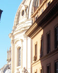 Cathedral dome with street lamp and building facade in foreground, a street scene in Rome