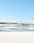 An abstract photograph featuring a blurred image of a beach with ocean waves meeting the shore.