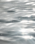 Ripples, sparkles and bubbles reflecting on grey ocean waters