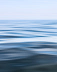 An abstract photograph of water surfaces with ripples, capturing shades of blue and white