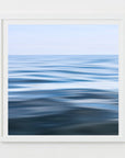 An abstract photograph of water surfaces with ripples, capturing shades of blue and white, with a white frame