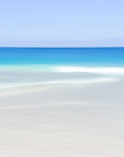 Fine art abstract photograph of a tropical beach scene with clear blue turquoise waters and a white sandy shore in the.