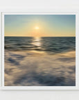 A scenic view of the ocean with a golden sunset glow, reflecting on the water surface.