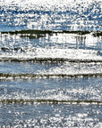 A photograph featuring a shimmering and sparkling blue body of water