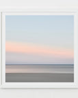 This image presents a soft and serene artwork capturing the essence of a sunset over Harwich Port, Cape Cod. The artwork features a minimalist design with a subtle blend of warm orange and pink hues on the horizon, gradually fading into cooler shades of blue and gray as the eye moves upward.