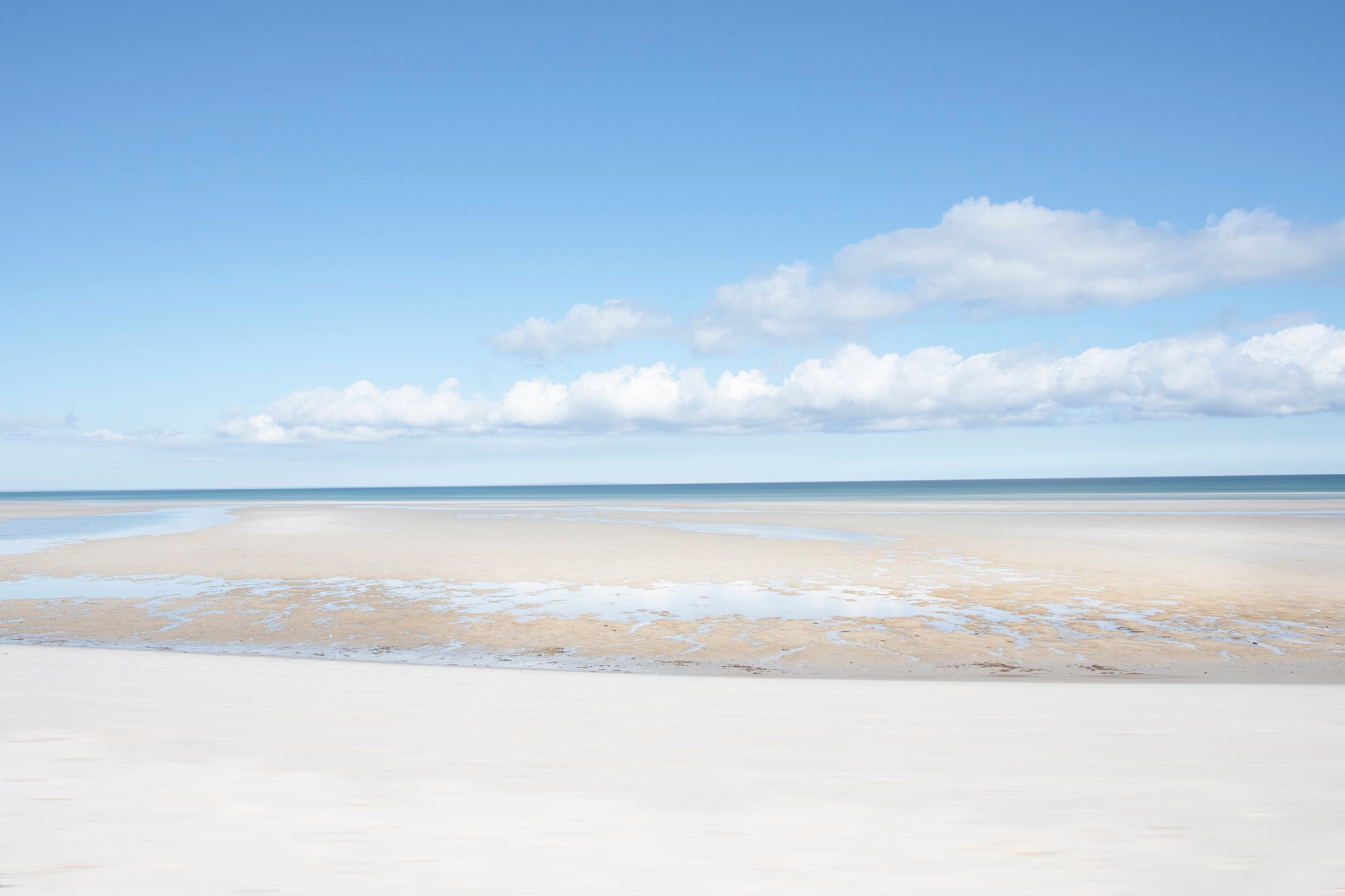 Capturing the quiet beauty of the Cape at low tide, where shallow water reflects the sky and creates a seamless blend.