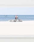 Framed artwork of a lifeguard chair on a beach with a white frame.