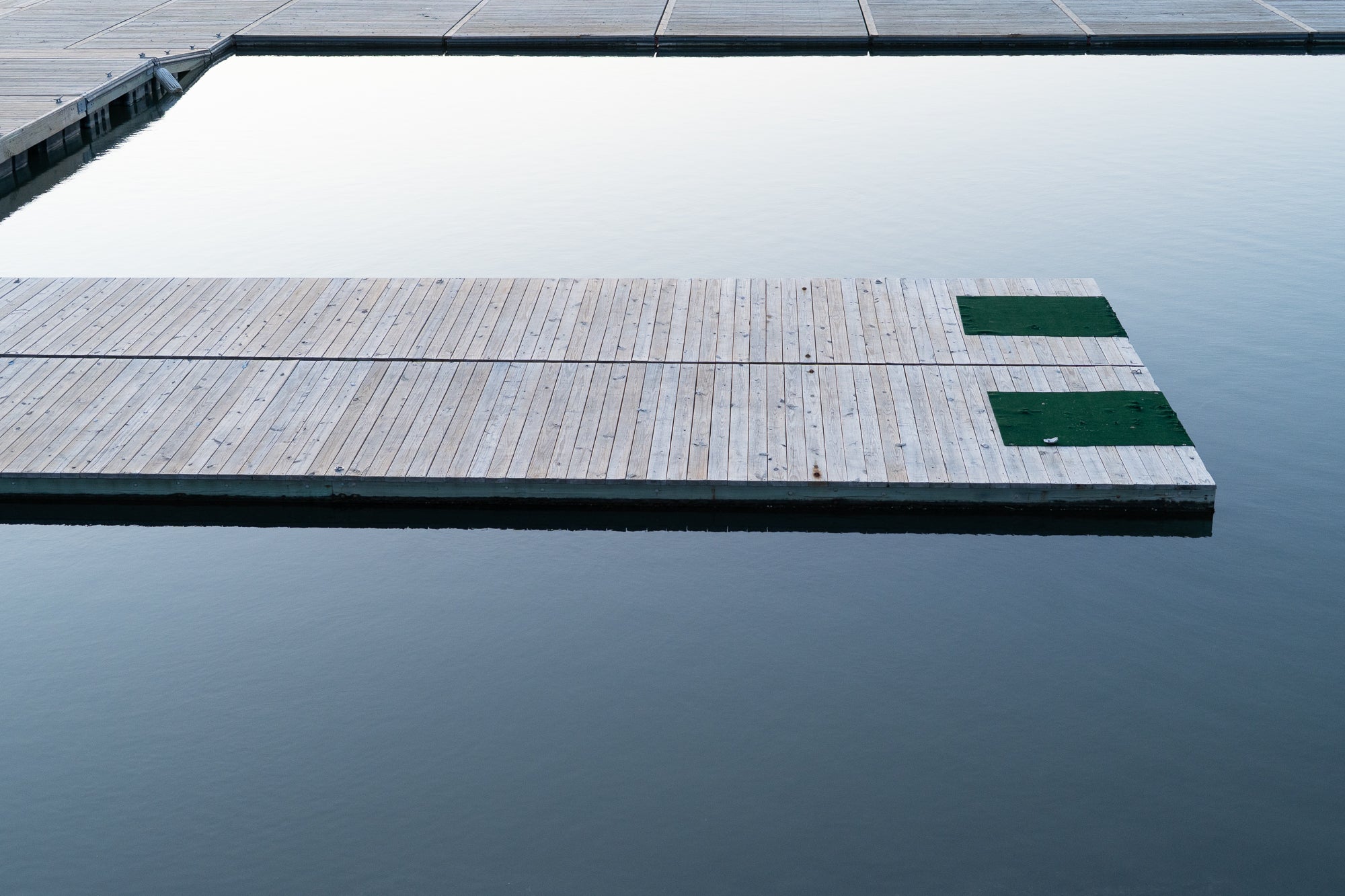 Wooden dock extending into a calm body of water 