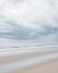 Beach scene of Nauset Beach, with blurred water and sand under a cloudy sky, featuring blue, grey and beige undertones