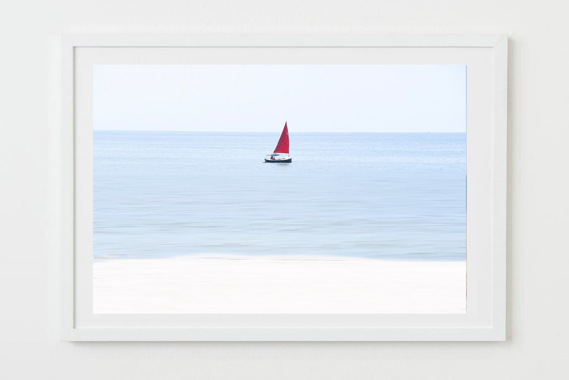 Framed artwork of a sailboat with a red sail on a blue background