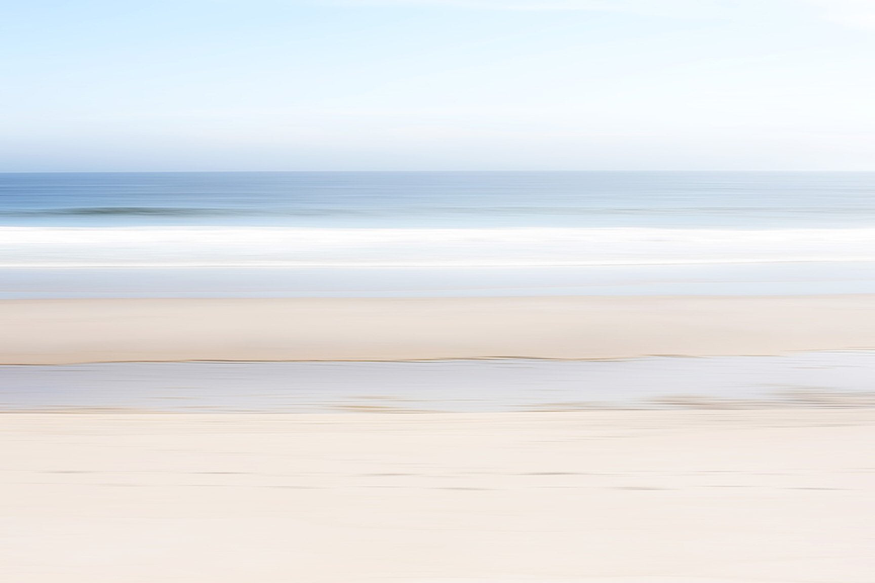 This image presents a fine art photograph  titled "Keep Going," featuring a serene beach scene in Orleans, Cape Cod. The artwork captures a minimalist landscape, showcasing the subtle textures of the beach sand and the gentle gradient of the ocean meeting the sky.