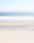This image presents a fine art photograph  titled "Keep Going," featuring a serene beach scene in Orleans, Cape Cod. The artwork captures a minimalist landscape, showcasing the subtle textures of the beach sand and the gentle gradient of the ocean meeting the sky.